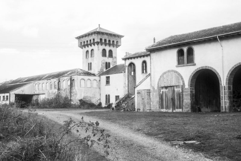Agricultural buildings on the Altyre Estate, Scotland. Pre renovation - stables and tower in poor state. Black and white photograph