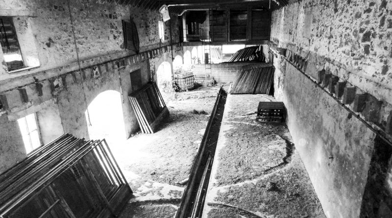 Internal view of colonnaded barn at Altyre Estate, Scotland. Pre renovation. Black and white photograph