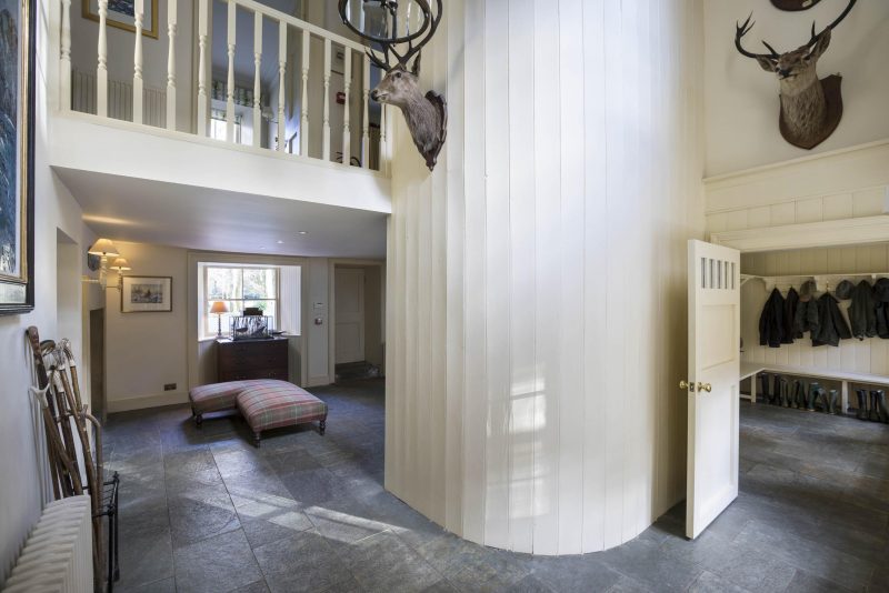 Renovated tongue and groove panelled hall at Knock House, Mull. Flagstone floor and gallery with timber spindles.