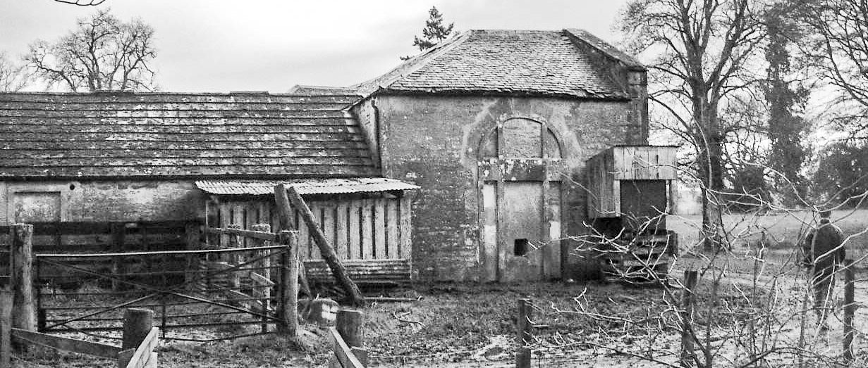 Dilapidated Byre on a Scottish estate in Perthshire. Trees and fencing in foreground.
